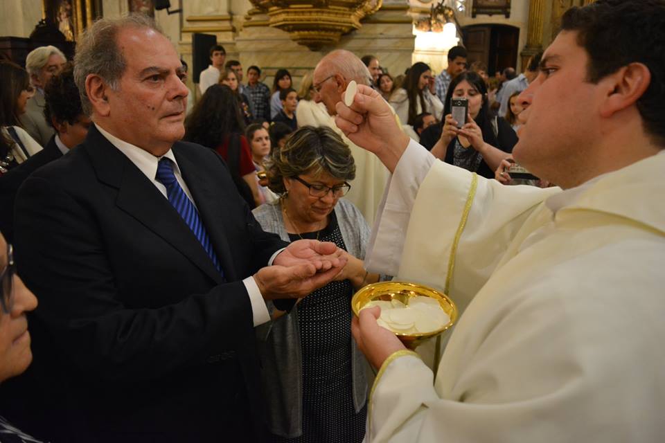 El nuevo sacerdote da la comunión a Rafael, su padre. A su lado está su madre, Graciela /C. Planelles