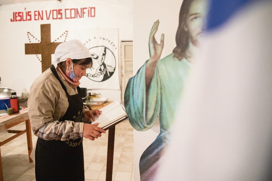 Paola lee un fragmento de la Biblia antes de comenzar a trabajar en la preparación de la cena de 230 personas.   /F. GUTIÉRREZ